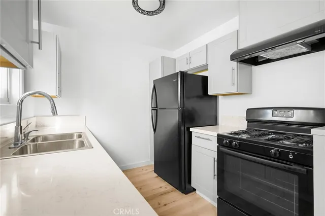 a kitchen with refrigerator and a sink