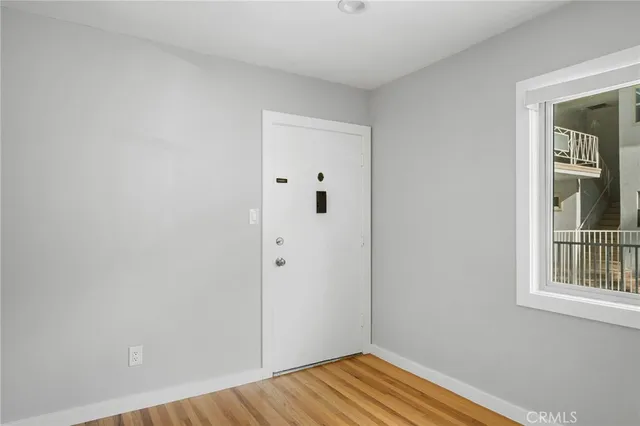 a view of a bedroom with wooden floor and cabinet