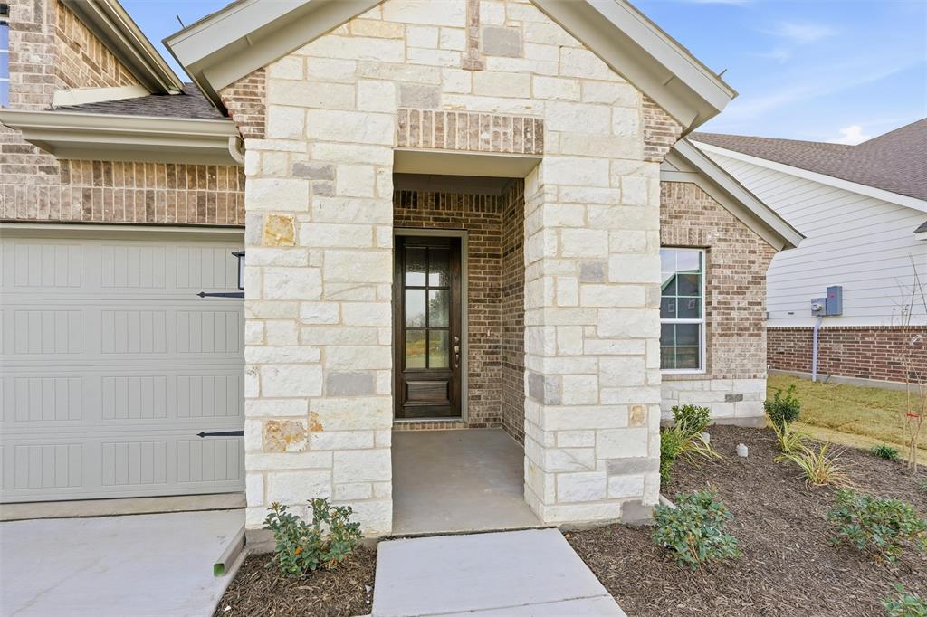 1244 Sabine River Lane Springtown, TX 76082 - Photo 5 of 26 Entrance to property featuring stone siding, a garage, and brick siding