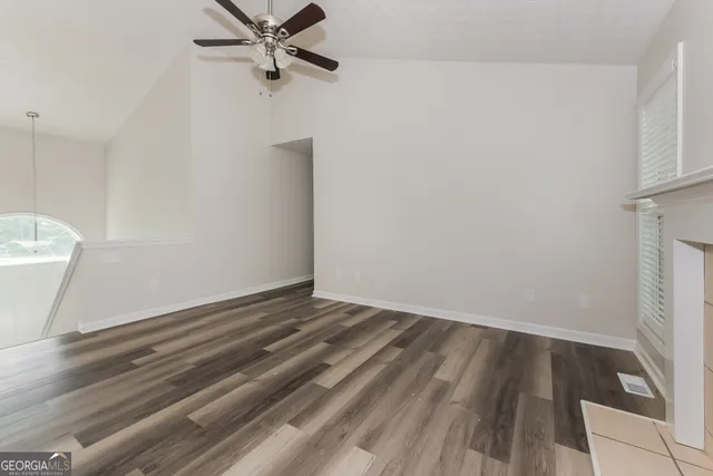 a view of a room with wooden floor and white walls