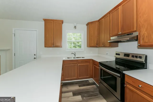 a kitchen with stainless steel appliances a stove a sink and cabinets