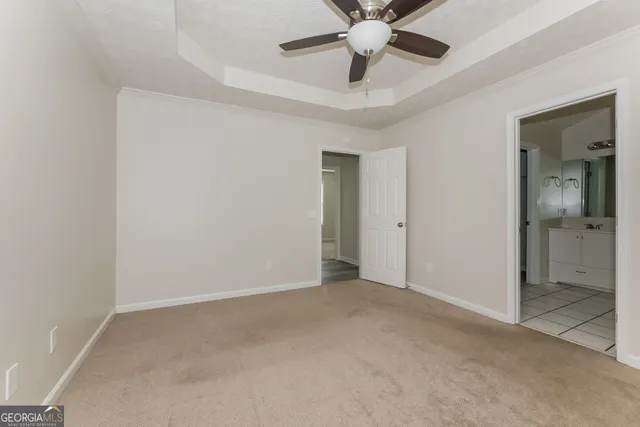 an empty room with closet and a chandelier fan