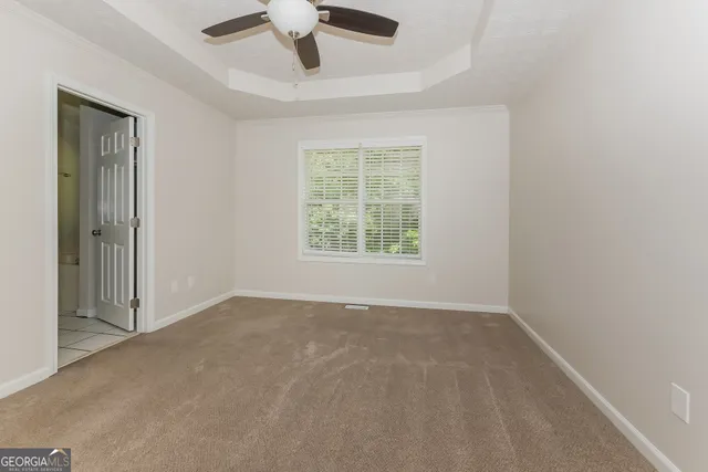 an empty room with a window and a ceiling fan