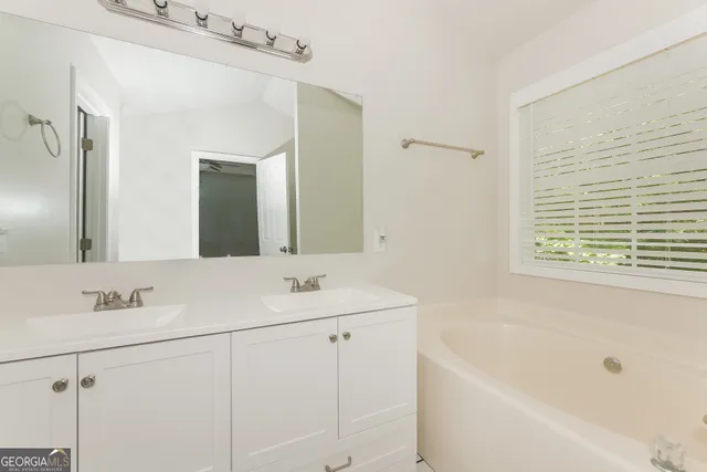 a bathroom with a tub sink and mirror