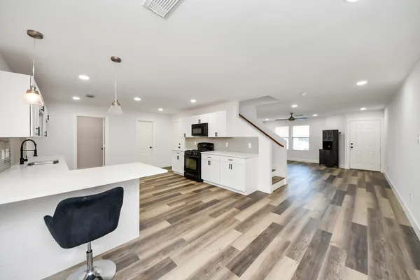 a view of empty room with wooden floor and ceiling fan