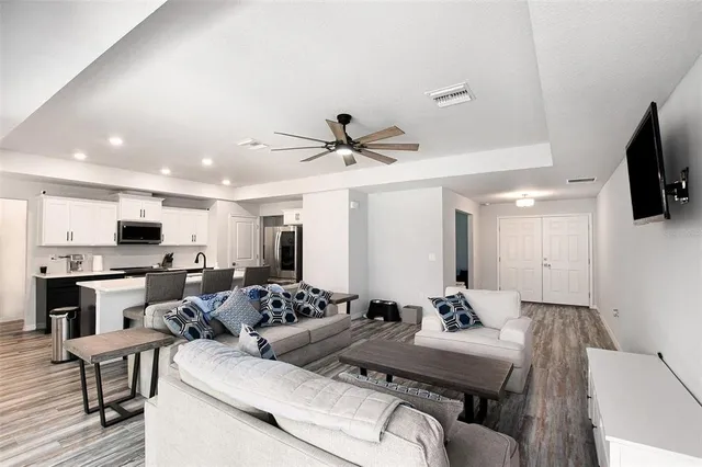 a living room with furniture kitchen and a flat screen tv