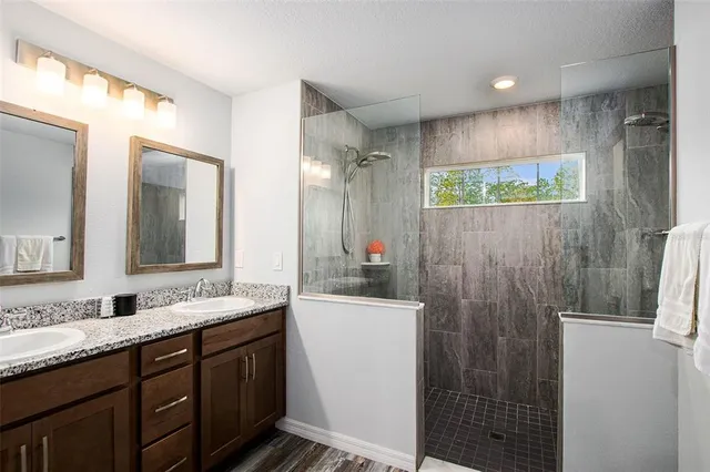 a bathroom with double vanity and a mirror