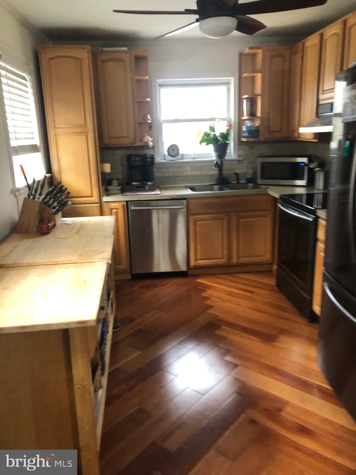 201 Southwood Road Pasadena, MD 21122 - Photo 5 of 16 a kitchen with stainless steel appliances granite countertop a sink a stove a refrigerator a microwave oven with wooden floor