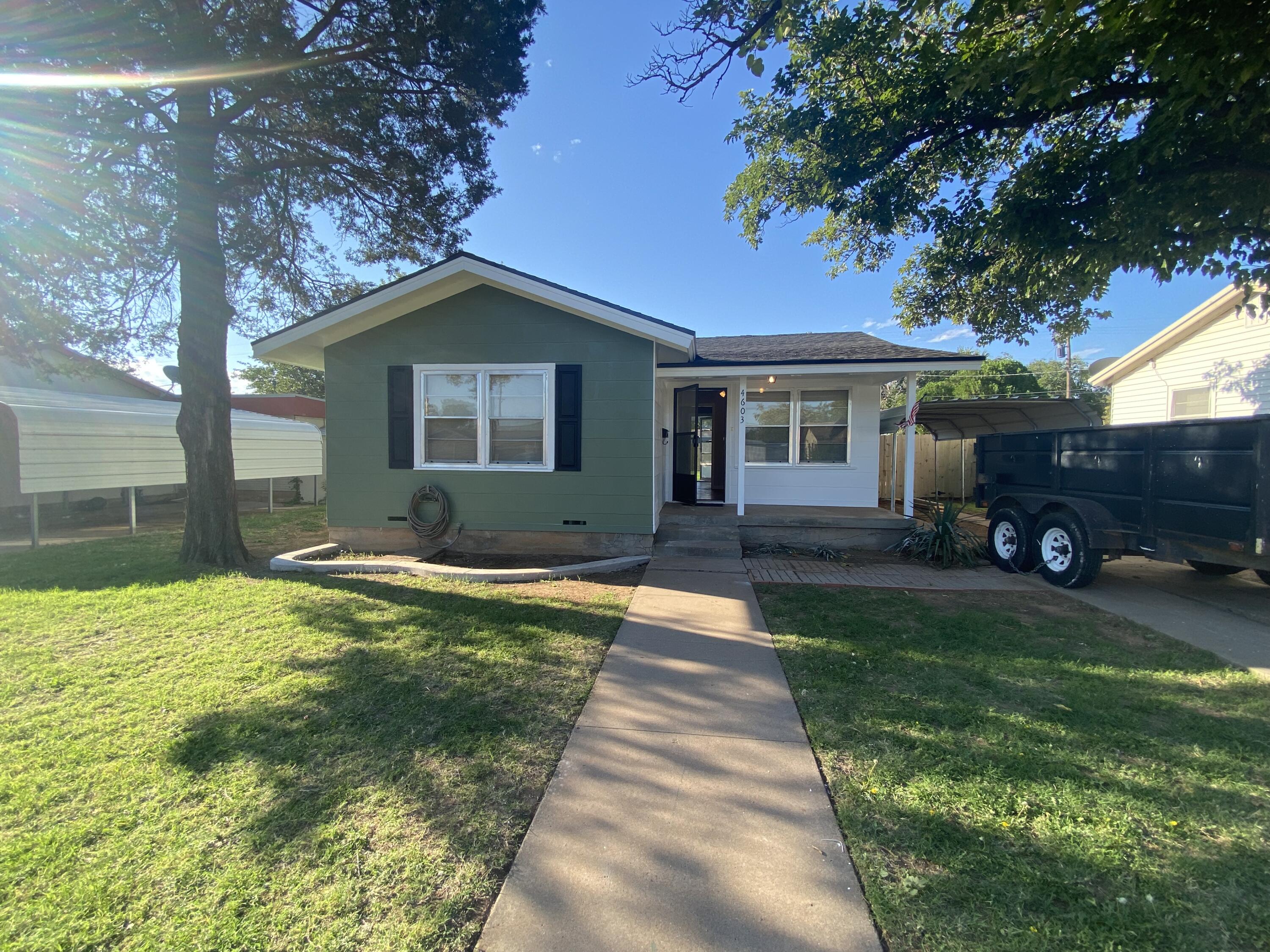 a backyard of a house with yard and outdoor seating