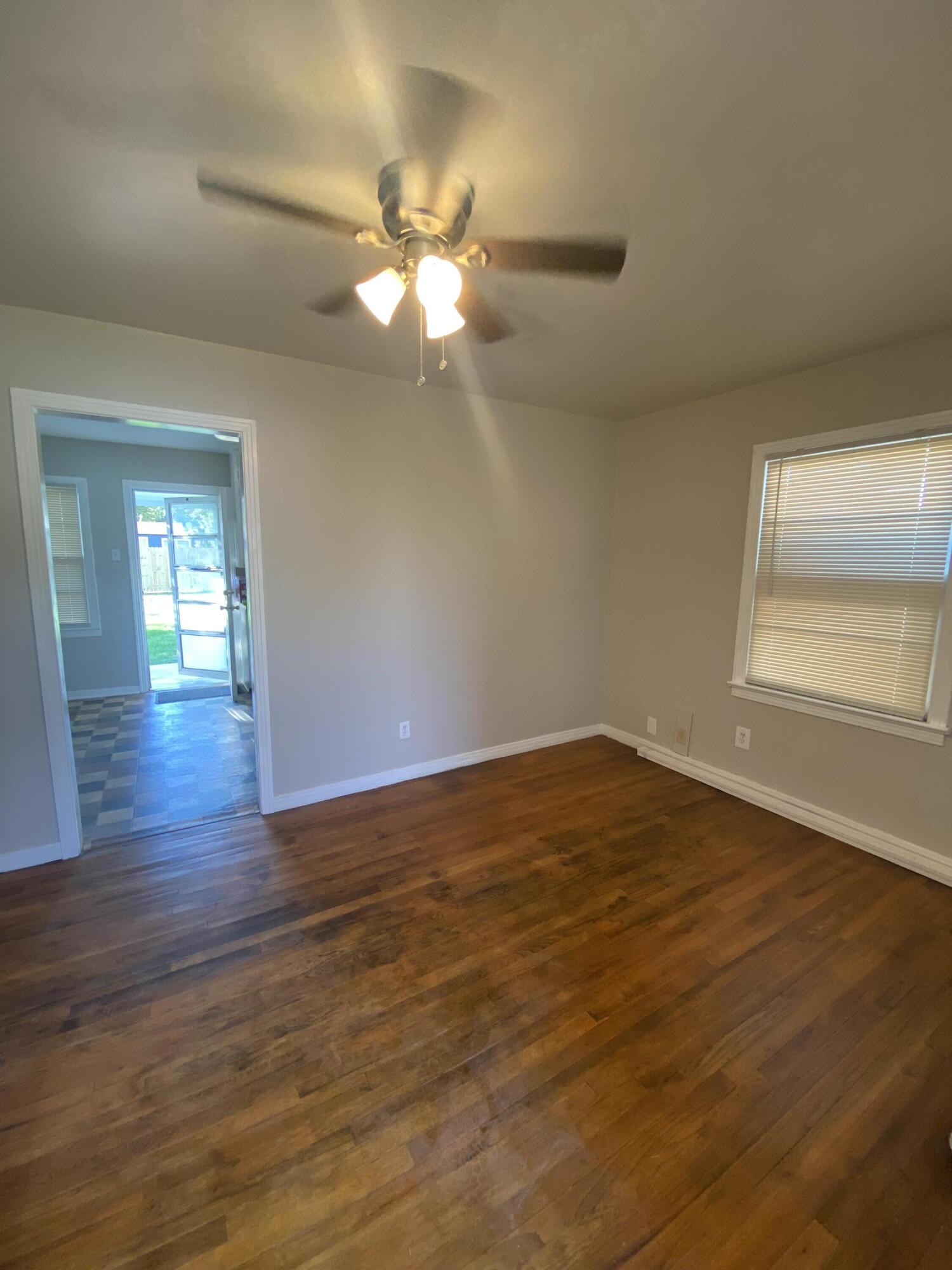 4603 45th Street Lubbock, TX 79414 - Photo 2 of 7 a view of an empty room with wooden floor and a window