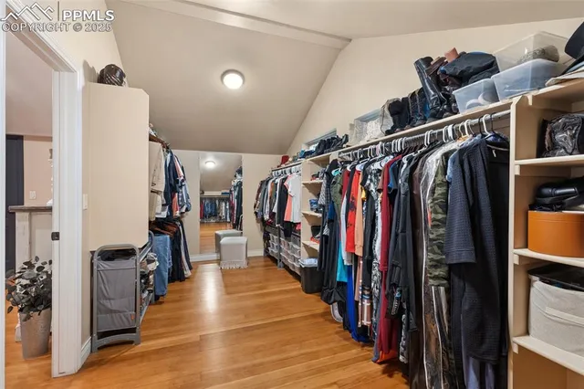 a view of walk in closet with clothes and shoes