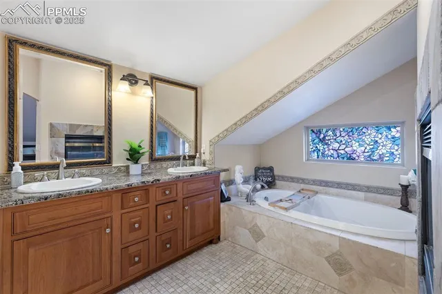 a spacious bathroom with a tub sink and mirror