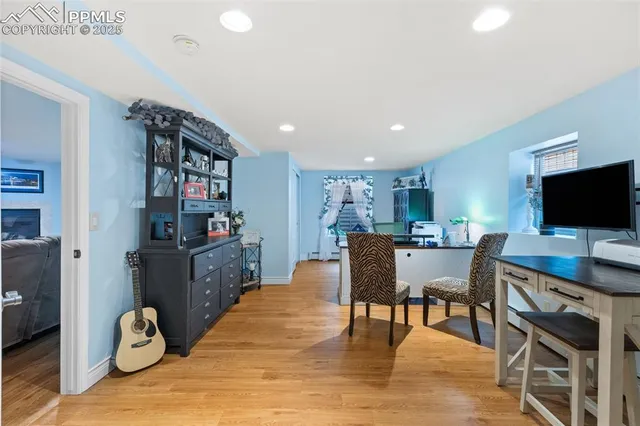 a view of a workspace with furniture and wooden floor