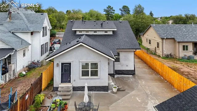a front view of a house with large trees