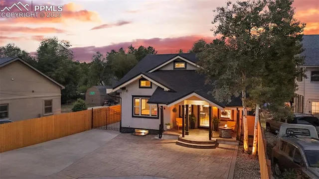 a front view of a house with a yard and potted plants
