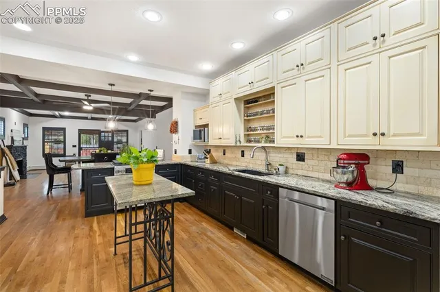 a kitchen with stainless steel appliances granite countertop a sink a stove counter space and cabinets