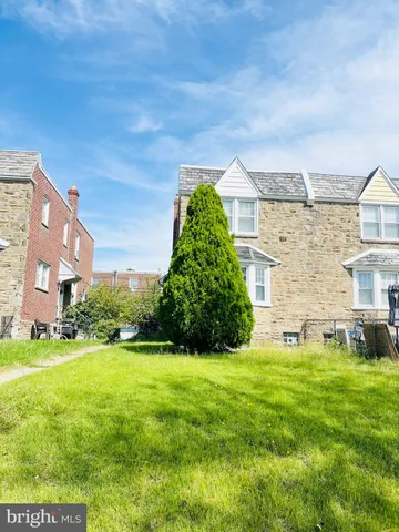 a view of a house with a big yard and large trees