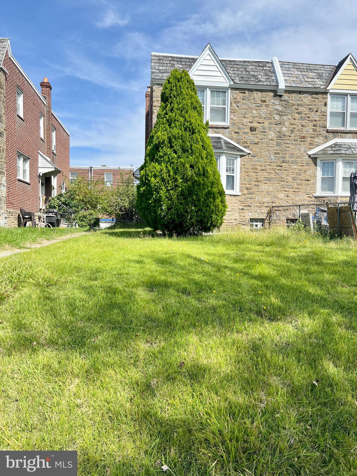 1113 Gilham Street Philadelphia, PA 19111 - Photo 2 of 9 a tall brick building with a yard in front of it