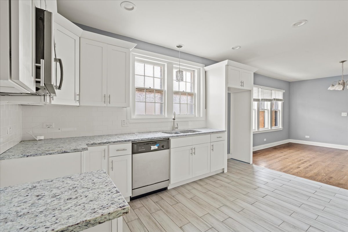 3111 Ruby Street Franklin Park, IL 60131 - Photo 12 of 27 a large kitchen with granite countertop a stove a sink and white cabinets with wooden floor