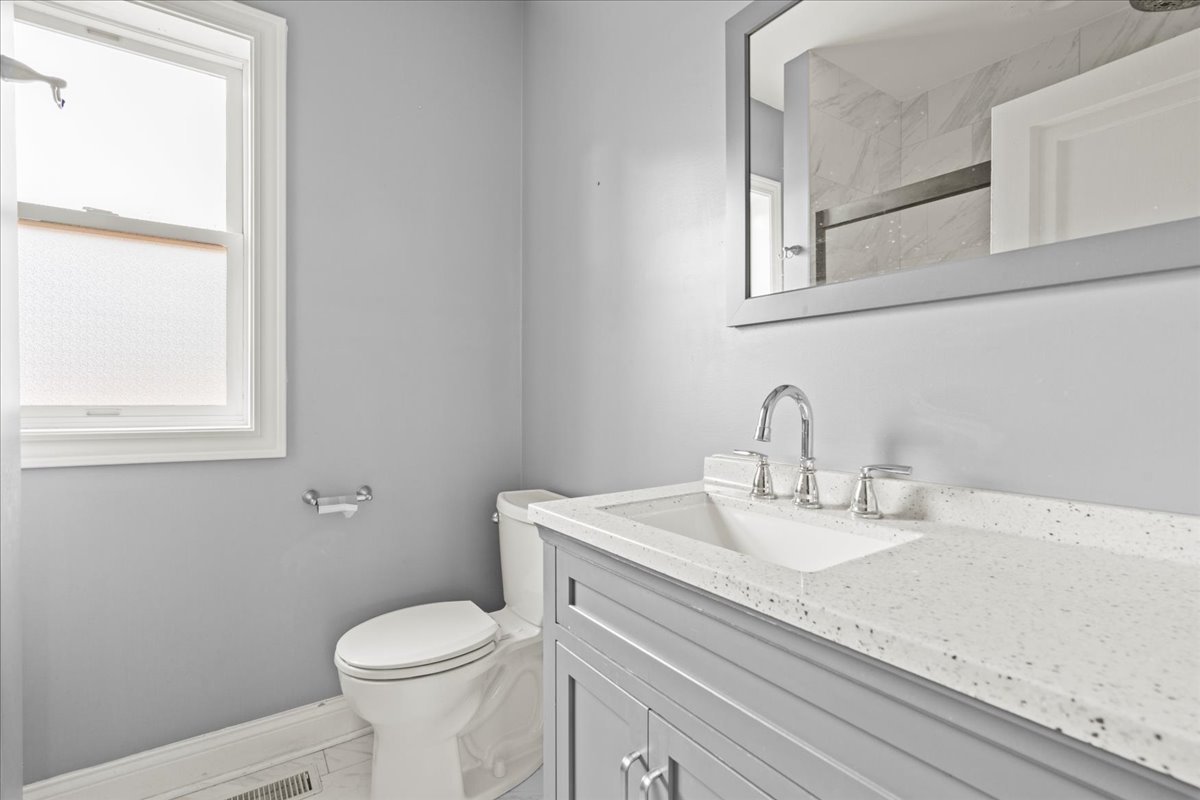 3111 Ruby Street Franklin Park, IL 60131 - Photo 9 of 27 a bathroom with a granite countertop toilet sink and mirror