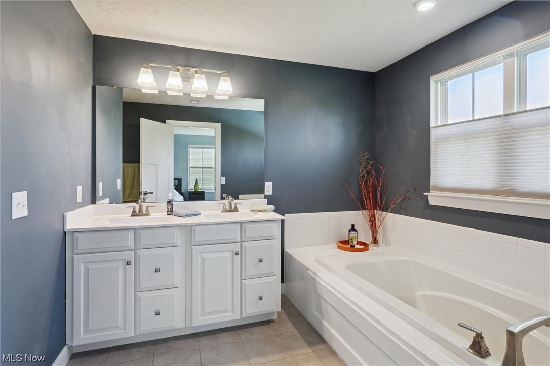 256 Stone Ridge Way Berea, OH 44017 - Photo 26 of 32 Bathroom featuring tile floors, dual vanity, and a washtub