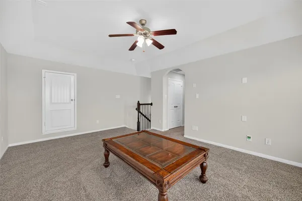 a living room with pool table and a ceiling fan