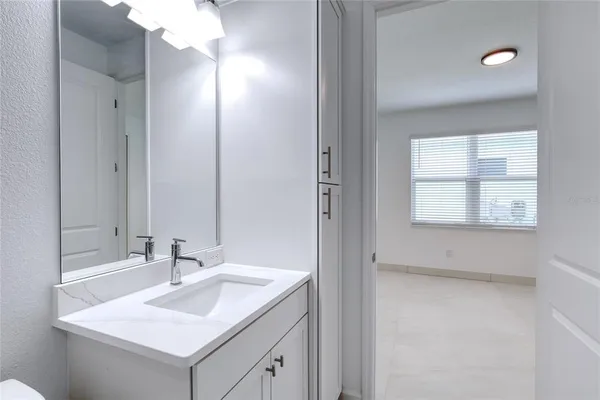 a bathroom with a granite countertop sink a mirror and a shower