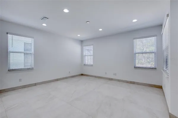 an empty room with an entryway and fan