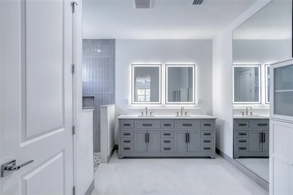 a view of a white house with a yard and large tree