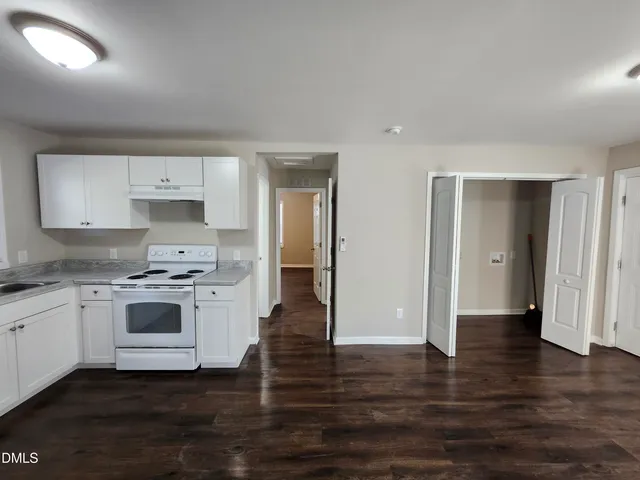 a kitchen with a stove and white cabinets