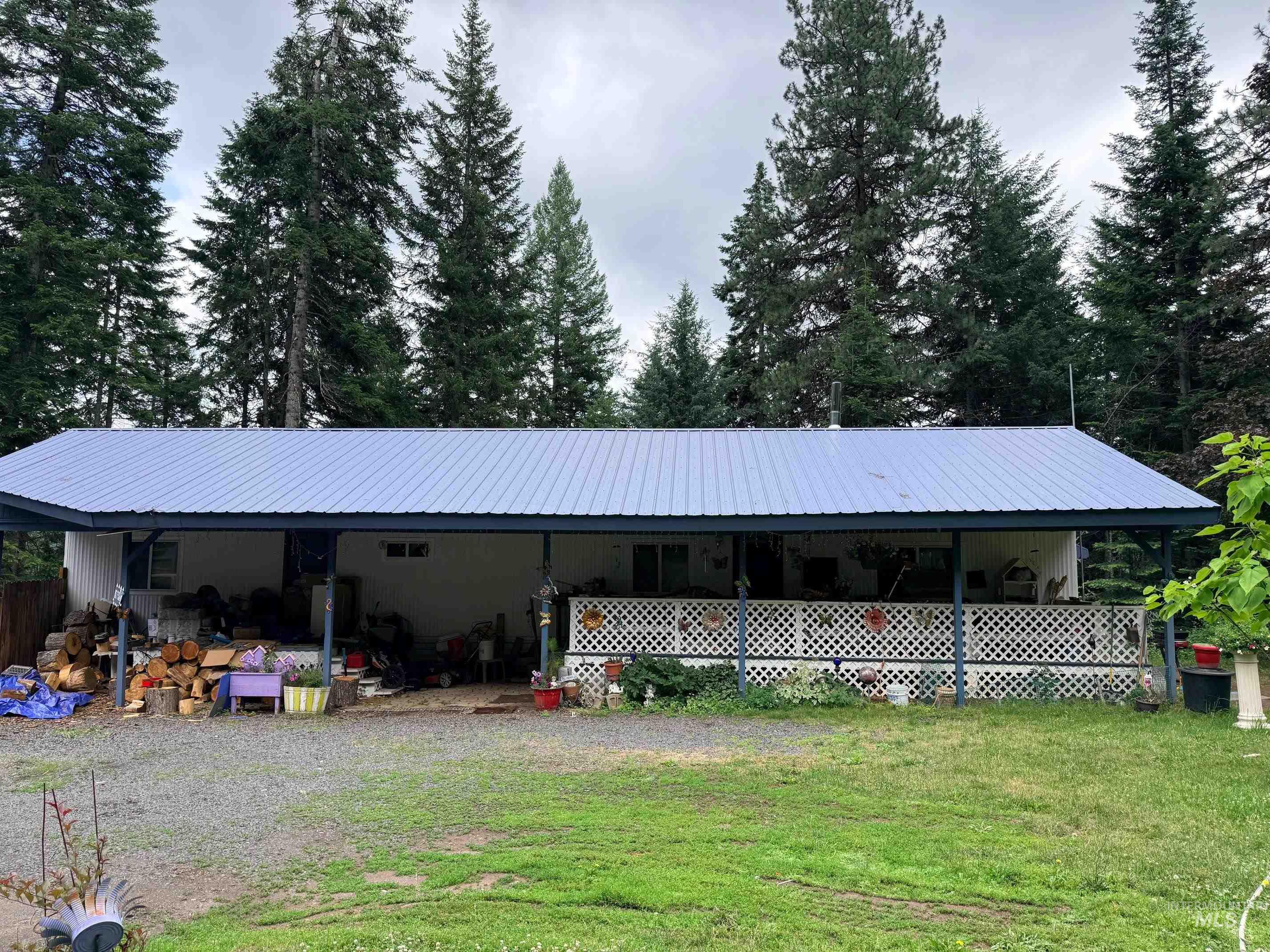 5742 Grangemont Road Orofino, ID 83544 - Photo 1 of 25 Single-story residence featuring a light blue metal roof and an extended covered porch