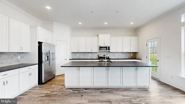 a kitchen with stainless steel appliances granite countertop a sink and refrigerator