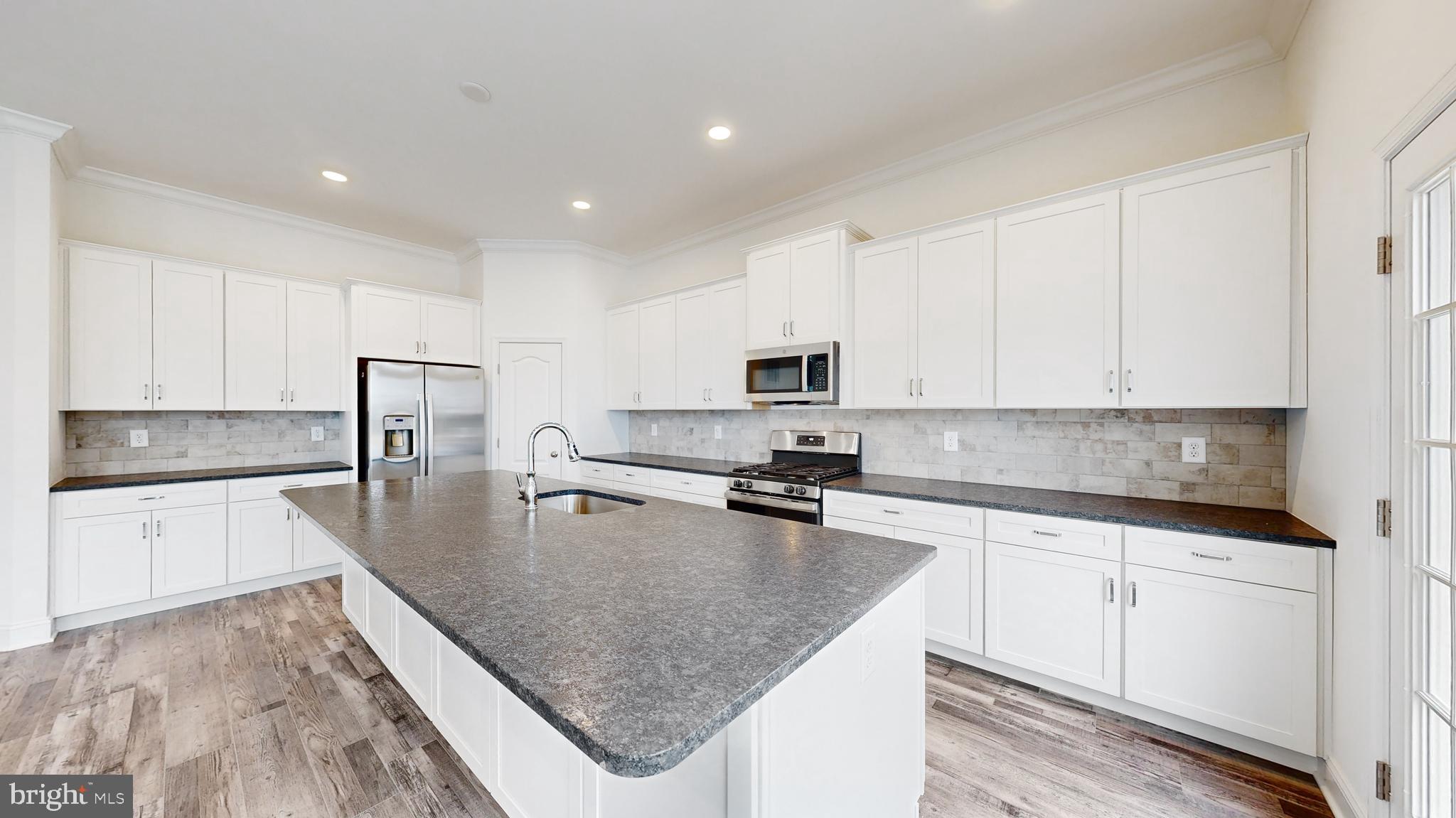 20727 Wilson Road Georgetown, DE 19947 - Photo 15 of 40 a kitchen with stainless steel appliances granite countertop a sink refrigerator and cabinets
