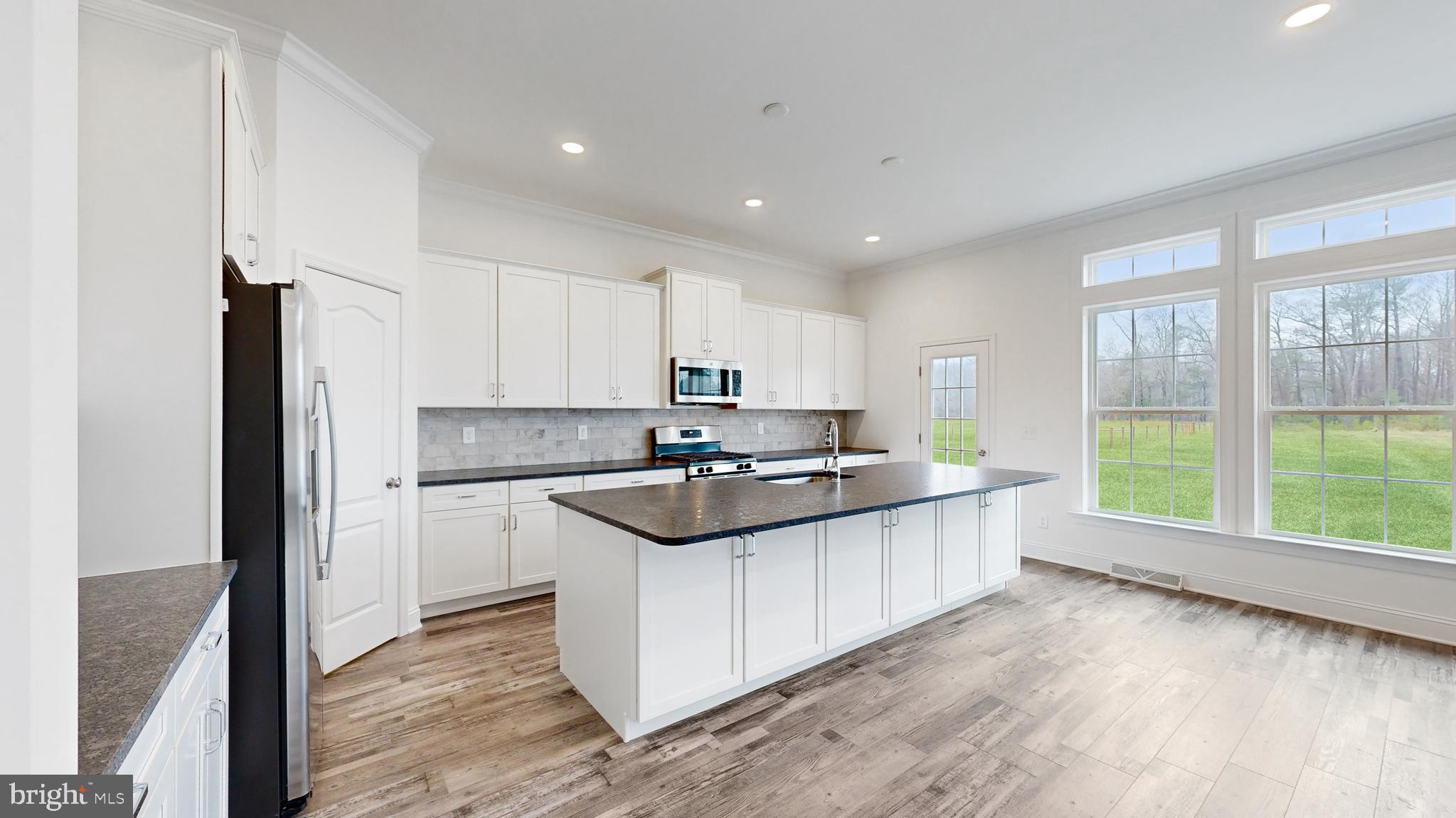 20727 Wilson Road Georgetown, DE 19947 - Photo 16 of 40 a kitchen with stainless steel appliances granite countertop a stove a sink and a refrigerator