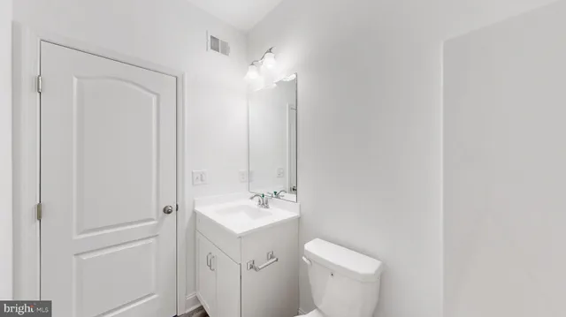 a bathroom with a toilet a sink and mirror
