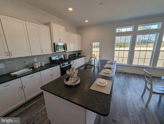 a kitchen with a dining table chairs and wooden floor