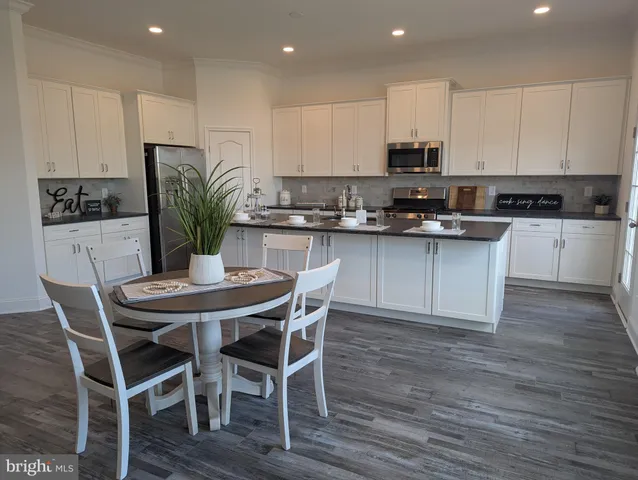 a kitchen with granite countertop white cabinets and wooden floor