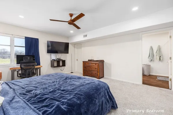 a spacious bedroom with a bed and a television