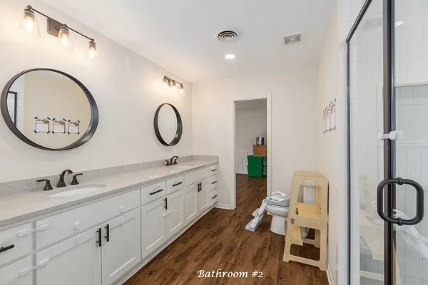 a bathroom with a granite countertop toilet a sink and a mirror