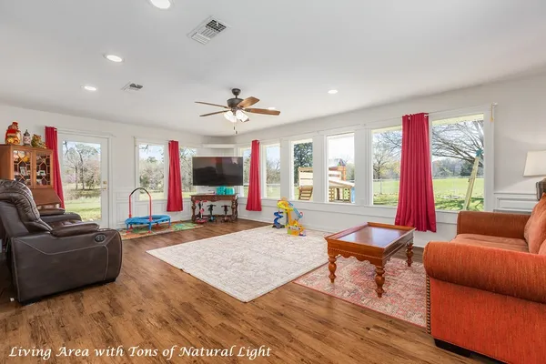 a living room with furniture a flat screen tv and a large window