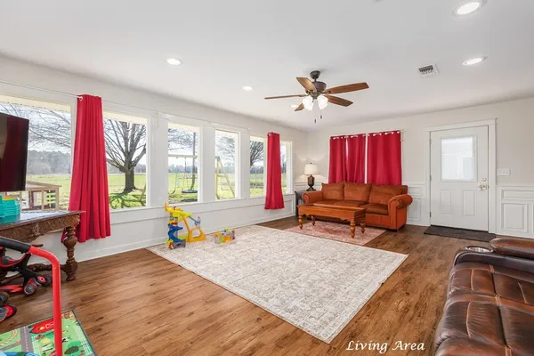 a living room with furniture a window and a flat screen tv
