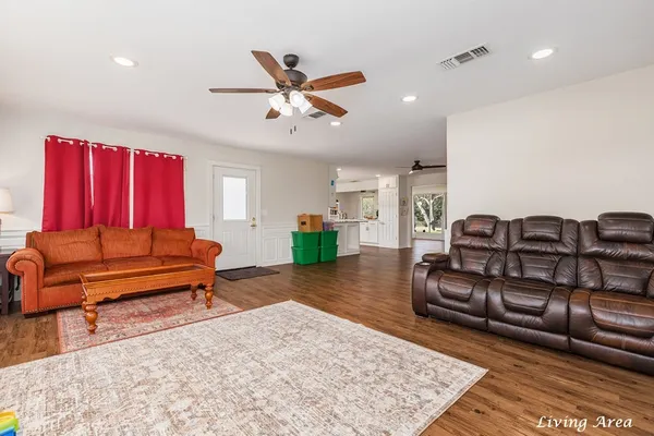 a living room with furniture and a wooden floor