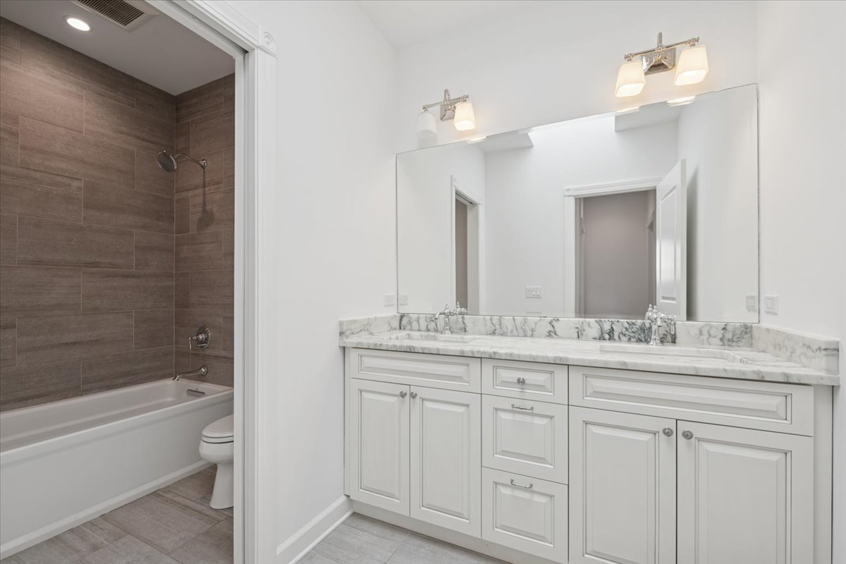 4036 North Parkside Avenue Chicago, IL 60634 - Photo 16 of 28 a bathroom with a double vanity sink and mirror with bathtub