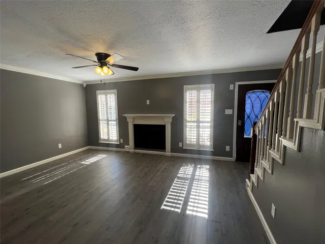 an empty room with windows and fireplace