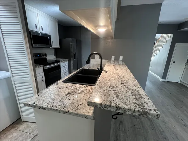 a kitchen with granite countertop a sink and a stove