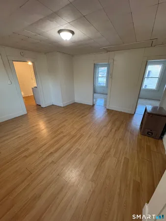 a view of empty room with wooden floor