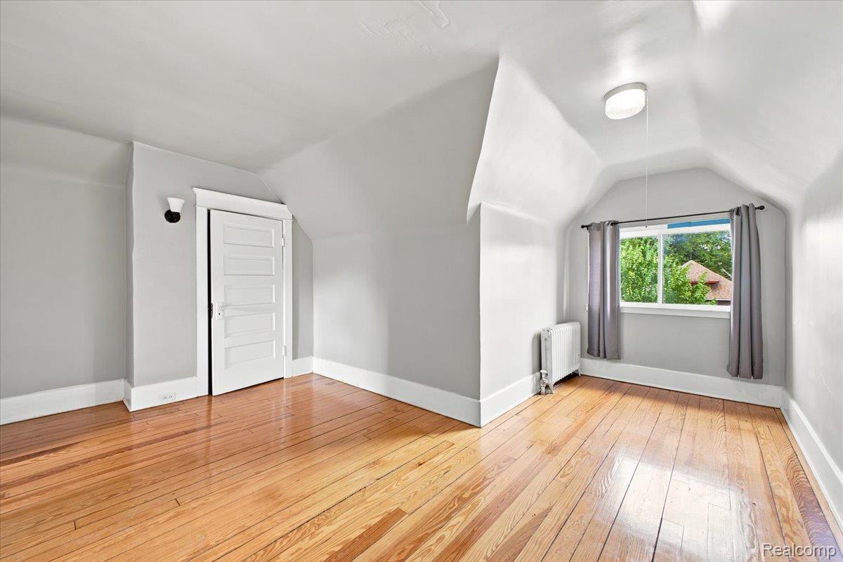 899 Edison Street Detroit, MI 48202 - Photo 25 of 37 Attic space featuring wood-finish flooring, white baseboards, and light gray walls