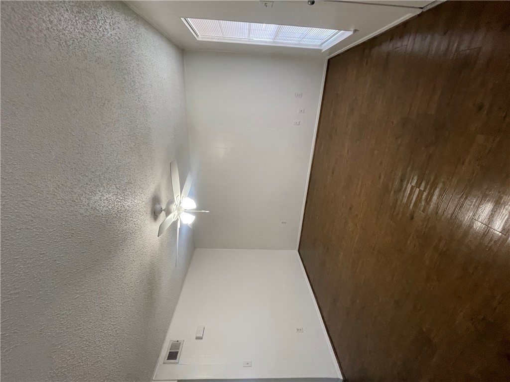 807 East 31st Street, Unit 1 Bryan, TX 77803 - Photo 3 of 7 a view of an empty room with wooden floor and fan