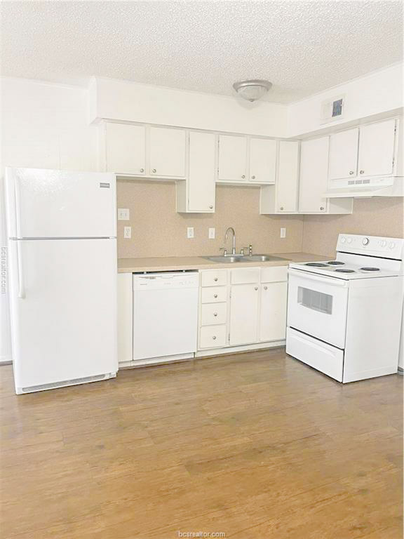 807 East 31st Street, Unit 1 Bryan, TX 77803 - Photo 5 of 8 a kitchen with granite countertop white cabinets and white appliances
