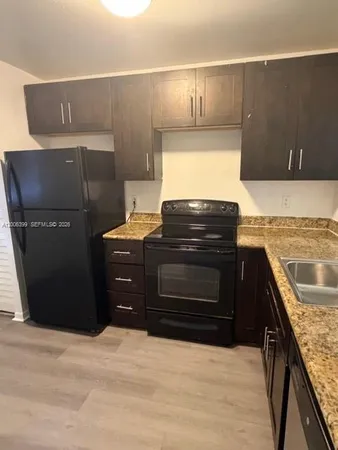a kitchen with granite countertop a stove and a refrigerator